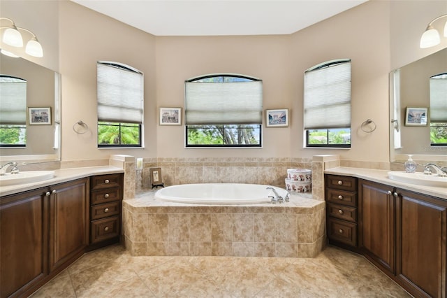 bathroom with vanity, a relaxing tiled tub, and tile patterned floors