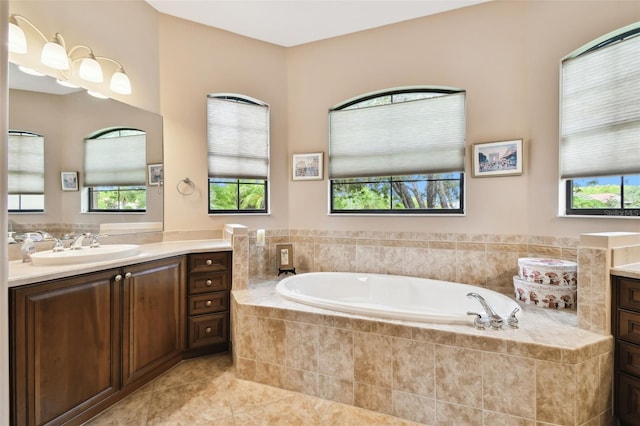 bathroom with vanity, tiled tub, tile patterned flooring, and plenty of natural light