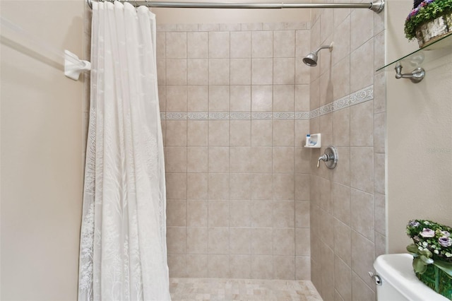 bathroom featuring toilet and curtained shower