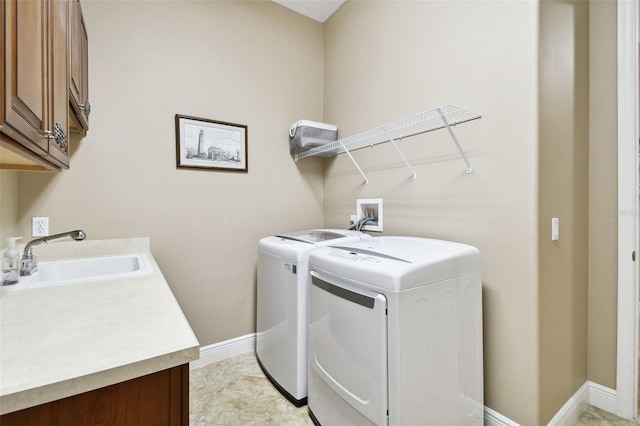 laundry room featuring cabinets, separate washer and dryer, and sink