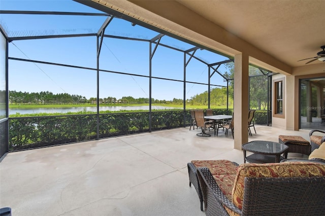 view of patio featuring a water view, ceiling fan, and a lanai