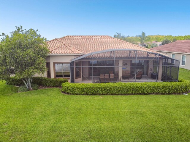 back of house featuring a lanai and a lawn