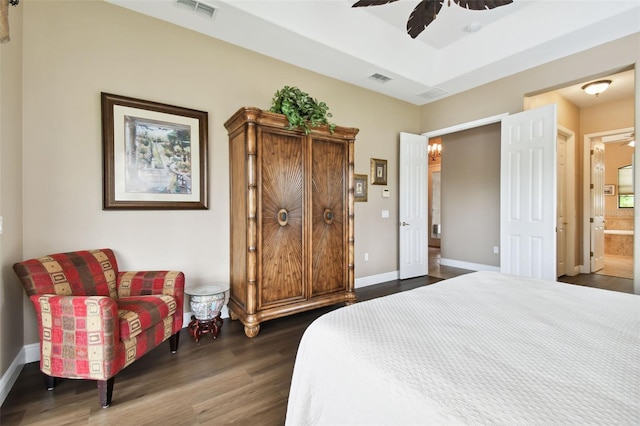 bedroom featuring dark wood-type flooring, ceiling fan, and connected bathroom