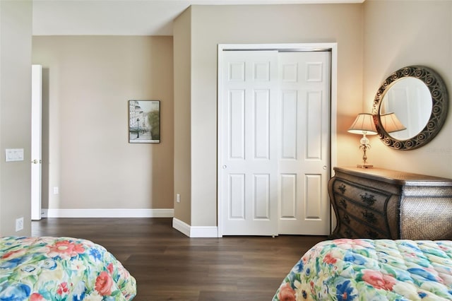 bedroom with dark wood-type flooring and a closet