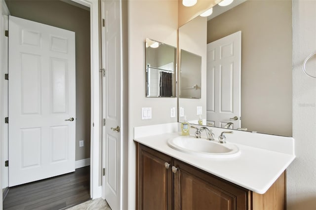 bathroom with hardwood / wood-style flooring, vanity, and a shower with shower curtain