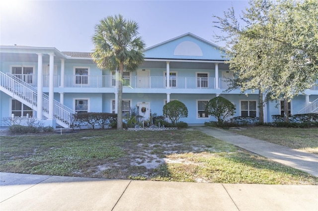 view of front of home with a front lawn and a balcony