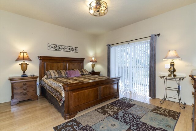 bedroom with access to exterior and light hardwood / wood-style floors