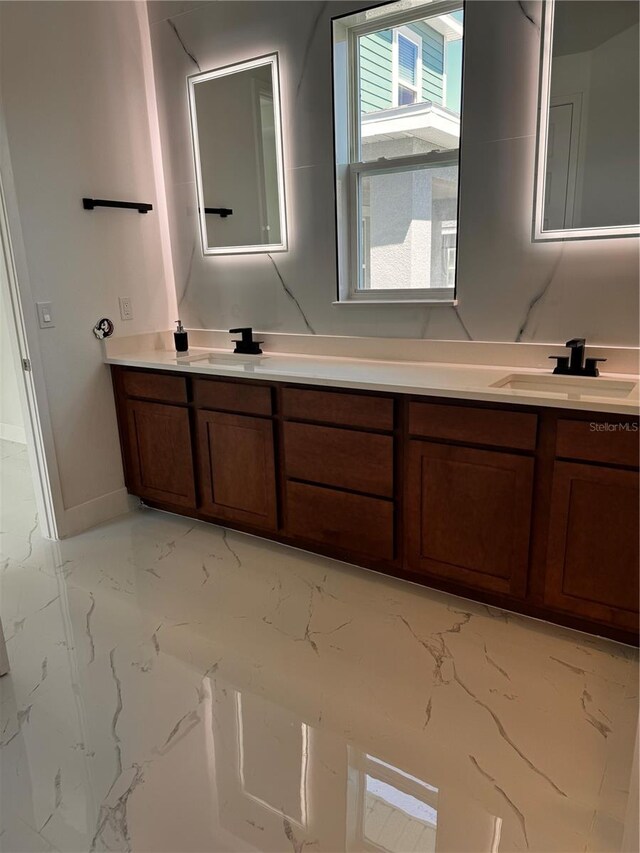 bathroom with tile patterned floors and dual bowl vanity