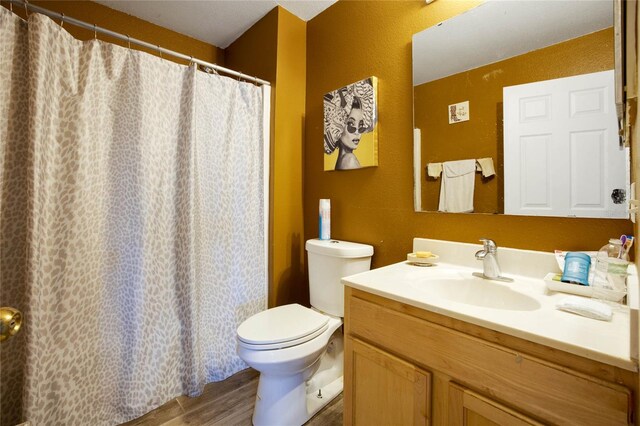 bathroom with hardwood / wood-style floors, vanity, and toilet