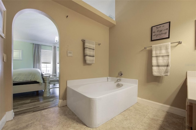 bathroom with tile patterned flooring, a bath, vanity, and ornamental molding