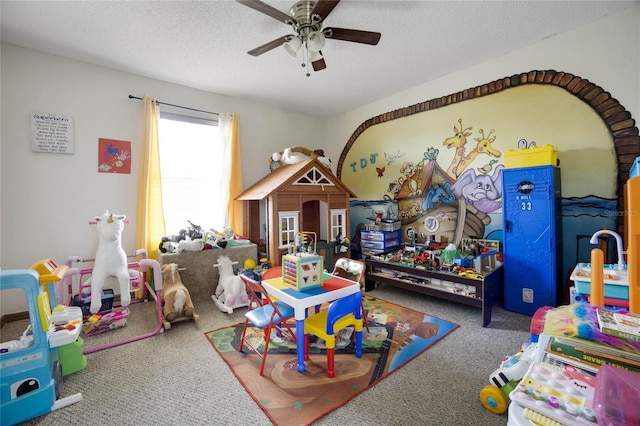 game room with ceiling fan, carpet floors, and a textured ceiling