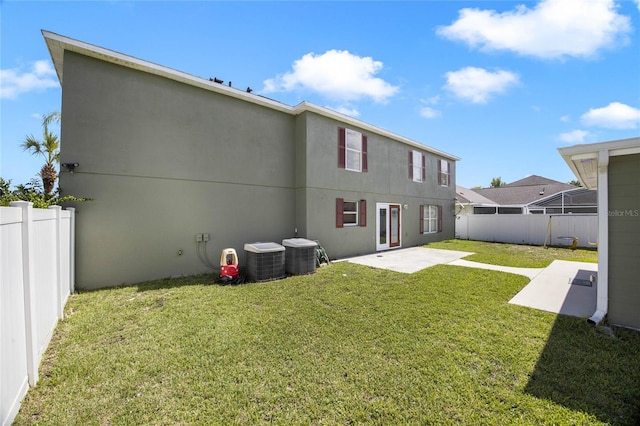 back of property featuring a yard, central AC, and a patio area