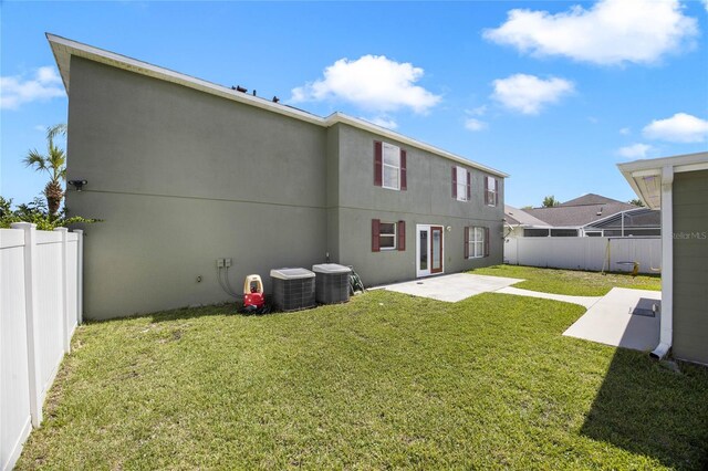 back of property featuring a yard, central AC, and a patio