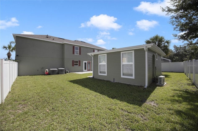 rear view of house featuring a yard and cooling unit