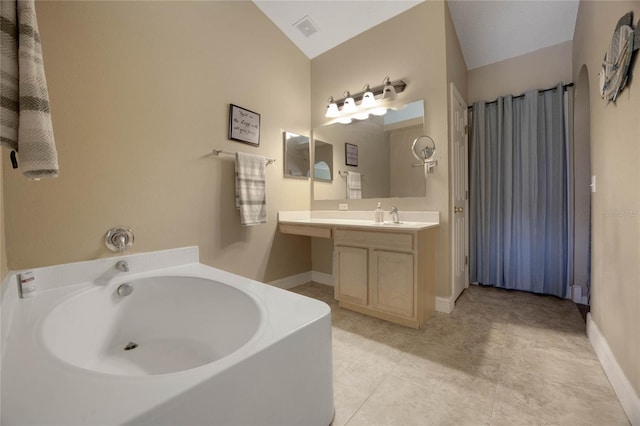 bathroom with a tub, tile patterned flooring, vanity, and lofted ceiling