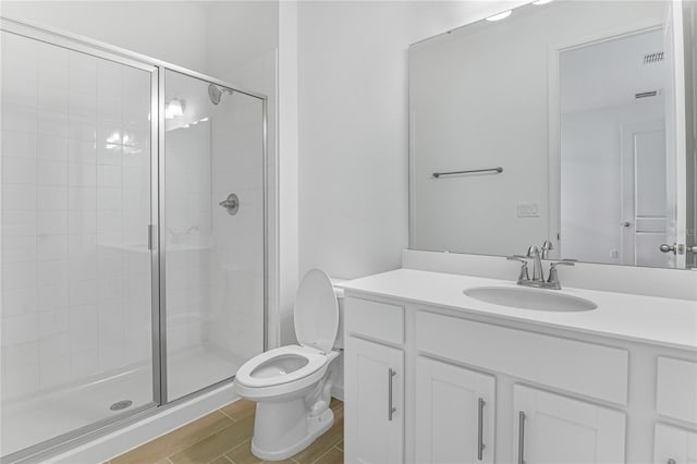 bathroom with vanity, a shower with shower door, and toilet