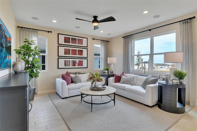 living room with ceiling fan and light wood-type flooring