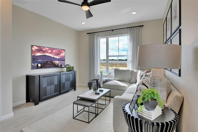 living room with light hardwood / wood-style flooring and ceiling fan