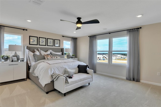 bedroom featuring light carpet, multiple windows, and ceiling fan