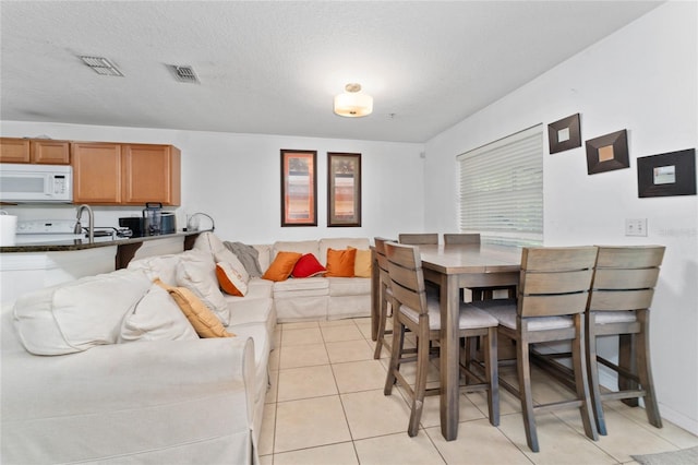 tiled dining area featuring a textured ceiling