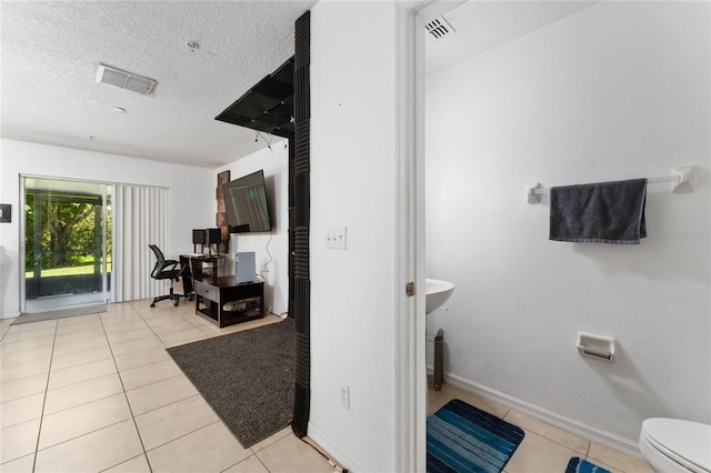 bathroom featuring tile patterned flooring, toilet, and a textured ceiling