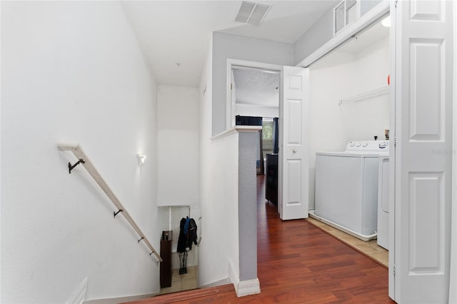 clothes washing area featuring separate washer and dryer and hardwood / wood-style flooring