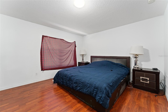 bedroom featuring a textured ceiling and hardwood / wood-style flooring