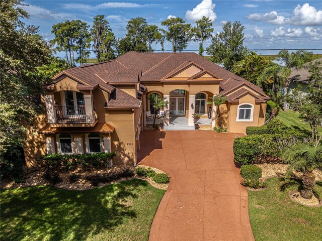 mediterranean / spanish house featuring a balcony and a front yard