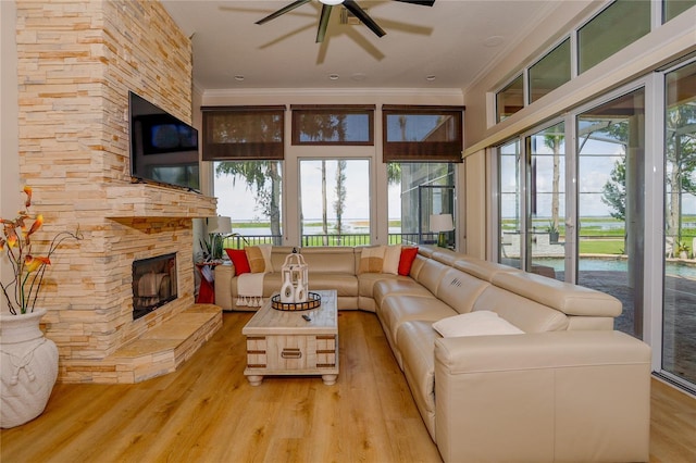 sunroom / solarium featuring ceiling fan, a fireplace, and a healthy amount of sunlight