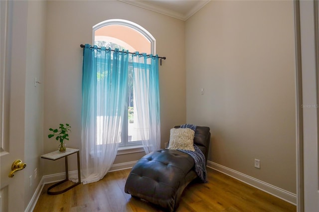 sitting room with ornamental molding and light hardwood / wood-style floors