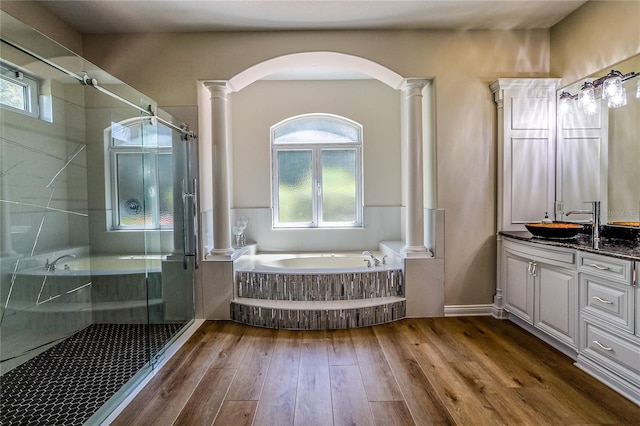 bathroom with vanity, shower with separate bathtub, and decorative columns