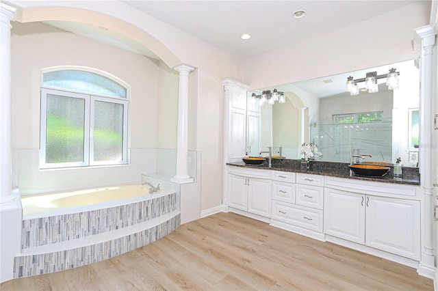 bathroom with vanity, shower with separate bathtub, decorative columns, and hardwood / wood-style floors