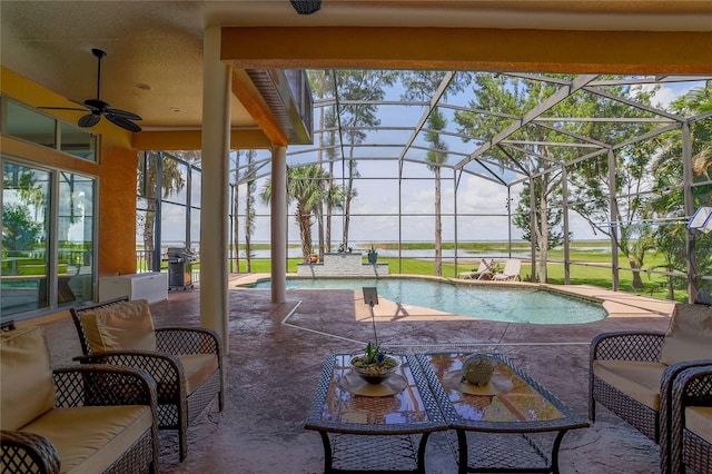 view of swimming pool featuring ceiling fan, glass enclosure, and a patio area