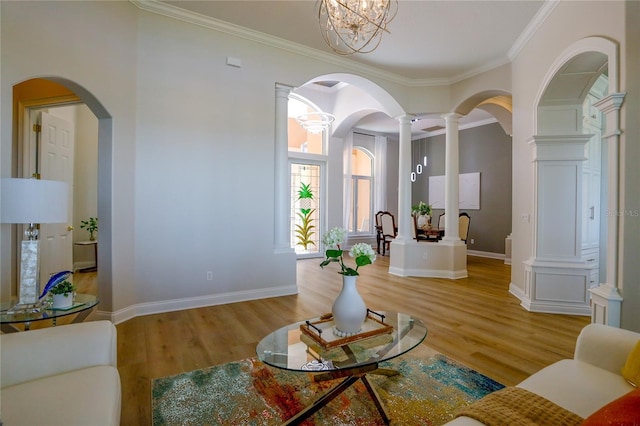 living room featuring decorative columns, ornamental molding, and hardwood / wood-style floors