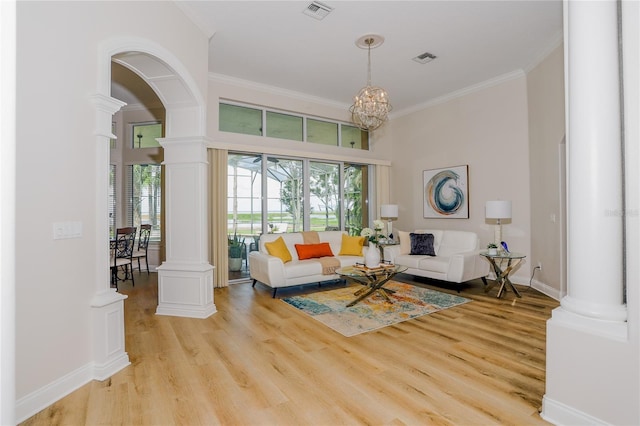 living room featuring crown molding, decorative columns, and light hardwood / wood-style flooring