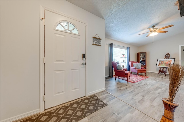 entryway with wood-type flooring, a textured ceiling, and ceiling fan