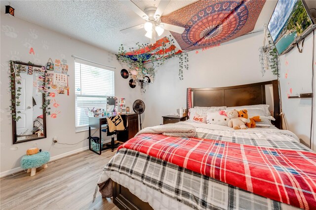 bedroom featuring hardwood / wood-style flooring, ceiling fan, and a textured ceiling