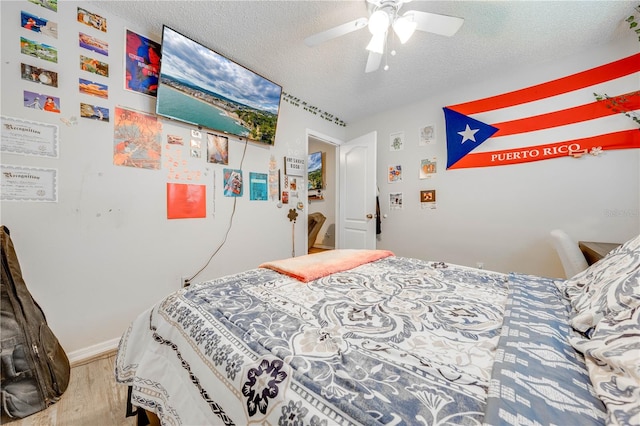 bedroom featuring a textured ceiling, ceiling fan, and hardwood / wood-style floors