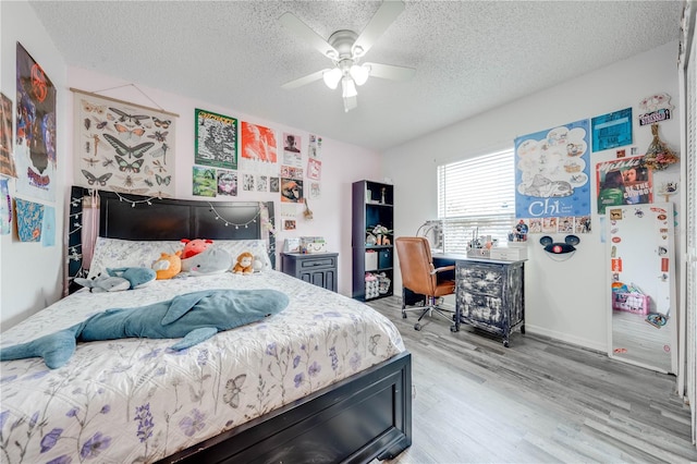 bedroom featuring hardwood / wood-style flooring, a textured ceiling, and ceiling fan