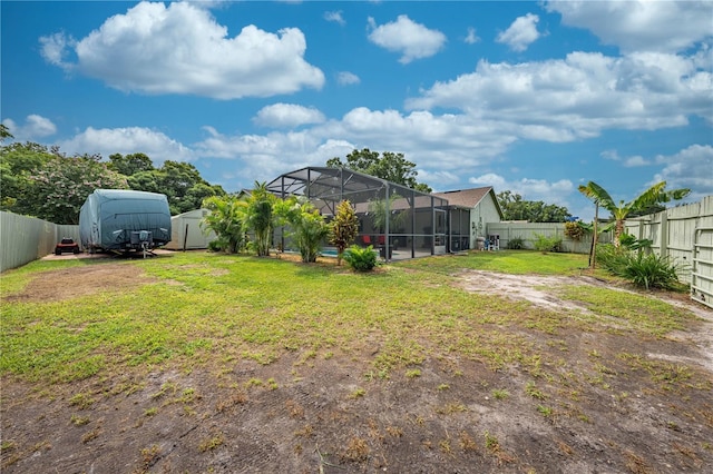 view of yard featuring a lanai and a storage unit