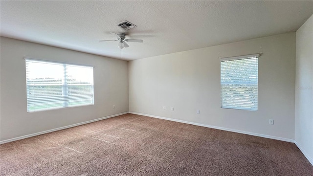 carpeted empty room with ceiling fan and a textured ceiling