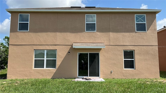 rear view of house featuring a lawn