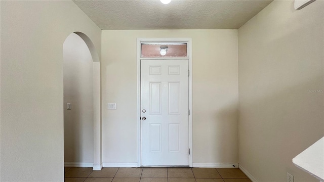 tiled entryway featuring a textured ceiling