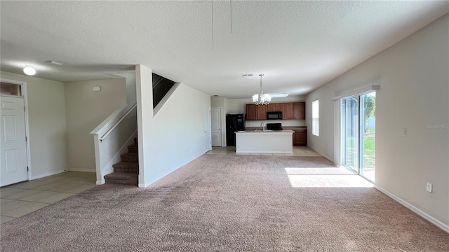 unfurnished living room with a textured ceiling, light carpet, and a chandelier