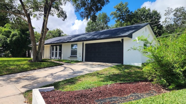 single story home featuring a garage and a front lawn