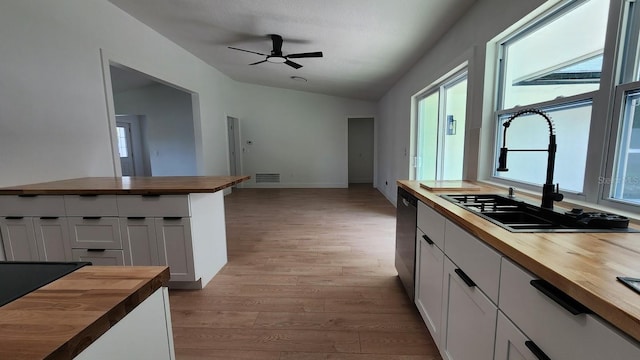 kitchen featuring wooden counters, light wood-type flooring, white cabinets, and vaulted ceiling