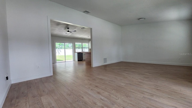 empty room featuring ceiling fan, light hardwood / wood-style floors, and a textured ceiling