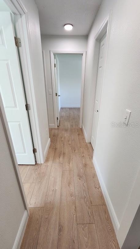 hallway with light hardwood / wood-style flooring