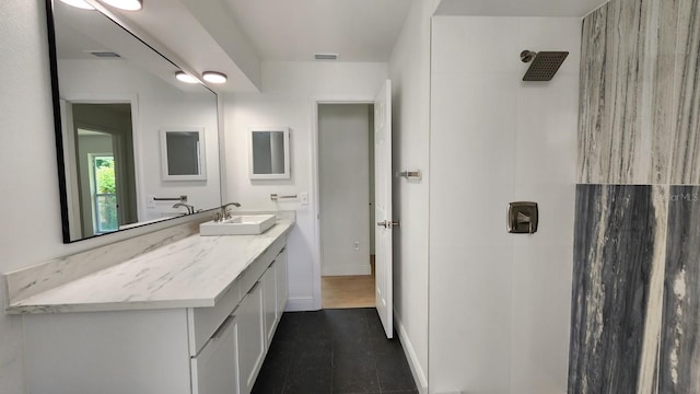 bathroom with a shower, vanity, and tile patterned floors