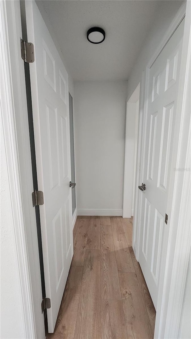 corridor with light hardwood / wood-style floors